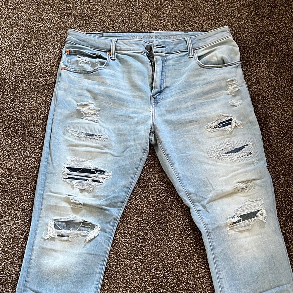Distressed American Eagle athletic skinny men’s jeans in light blue wash.